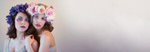 - Marion Salon Spa in Salt Point, NY Two women with colorful makeup and flower crowns stand close together against a pale background, their eyes accentuated by volume eyelash extensions as they look directly at the camera. - Marion Salon Spa in Salt Point, NY