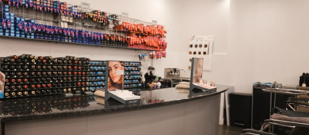 - Marion Salon Spa in Salt Point, NY A modern salon counter with hair color products organized on shelves behind it and product displays on the counter, including special sections highlighting the balayage hair color technique for clients seeking natural, sun-kissed tones. - Marion Salon Spa in Salt Point, NY